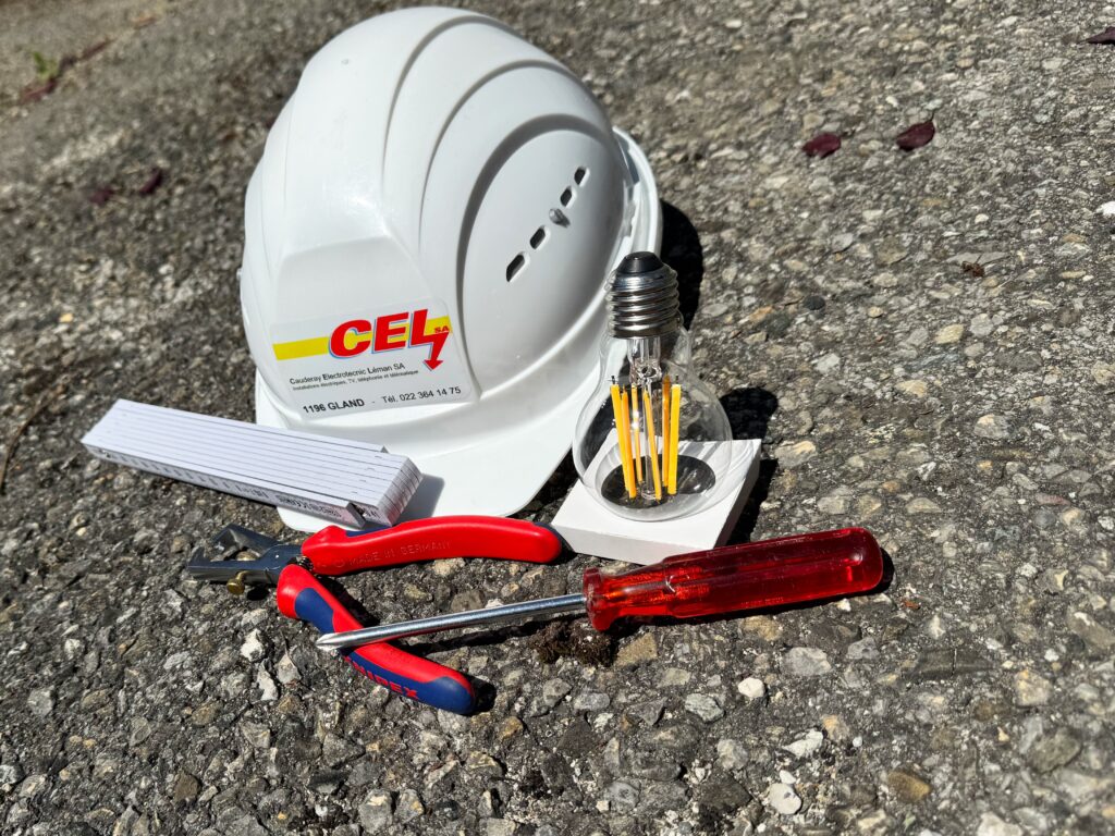 Casque de chantier avec écrit CEL dessus et des outils devant