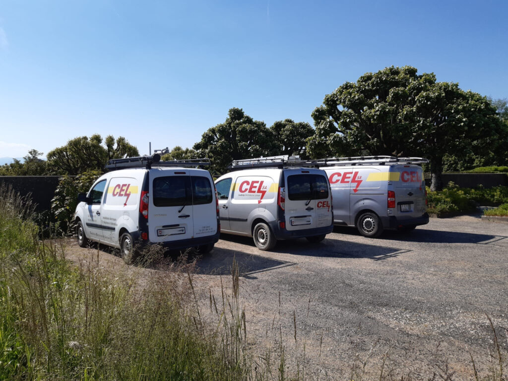 Trois camionnettes de l'entreprise CEL parqué en ligne